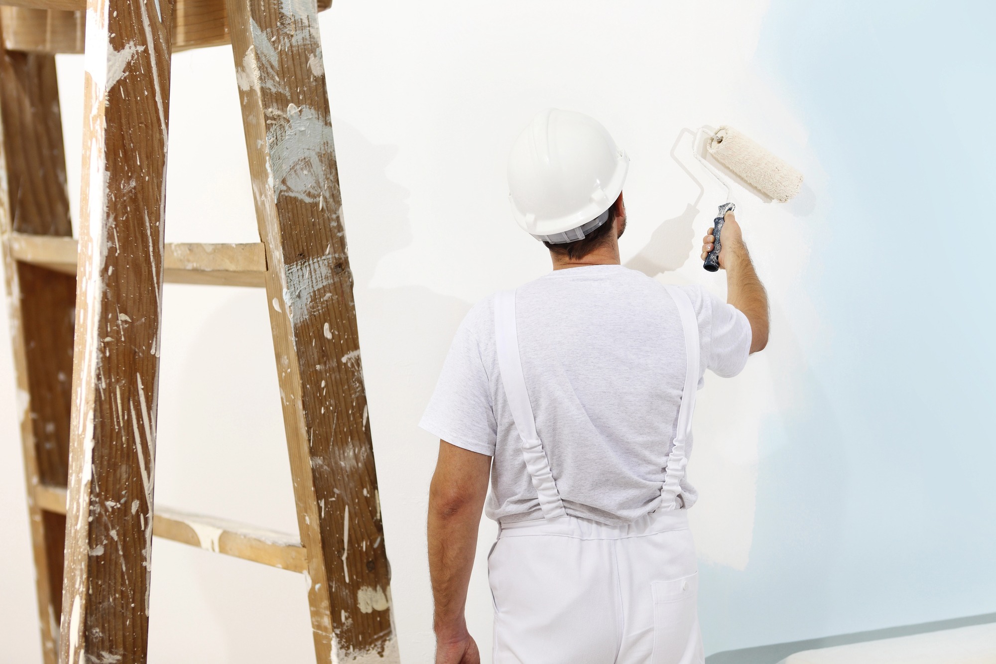 Maler streicht eine Wand sorgfältig weiß